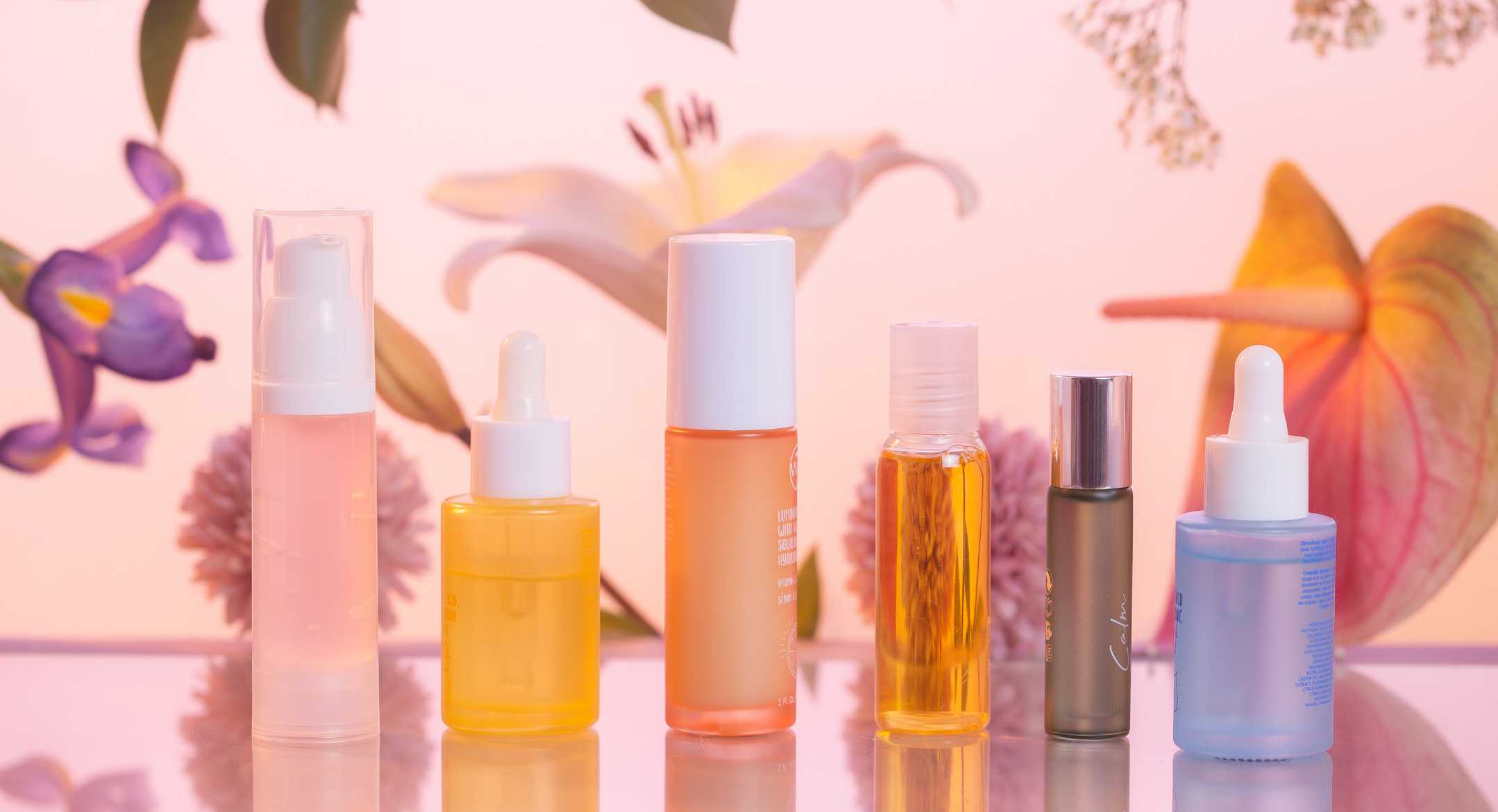Skincare products line up with flowers on the background