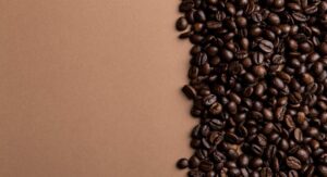 Coffee beans scattered on a light brown table