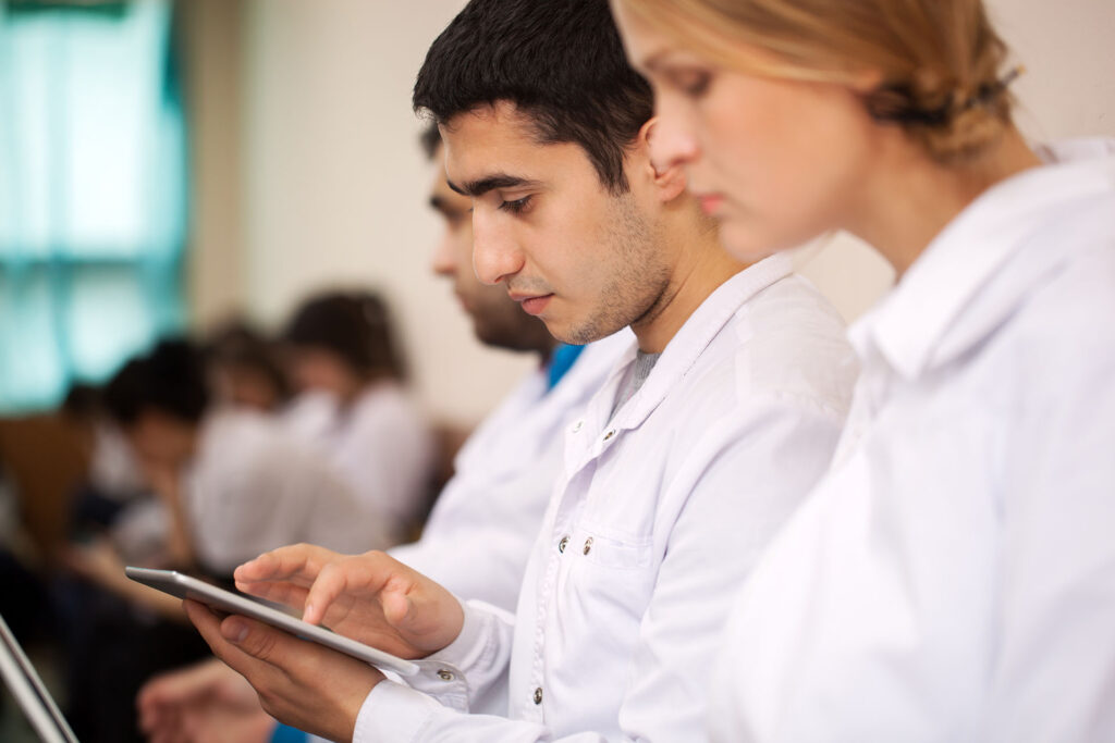 People wearing white coats using an ipad