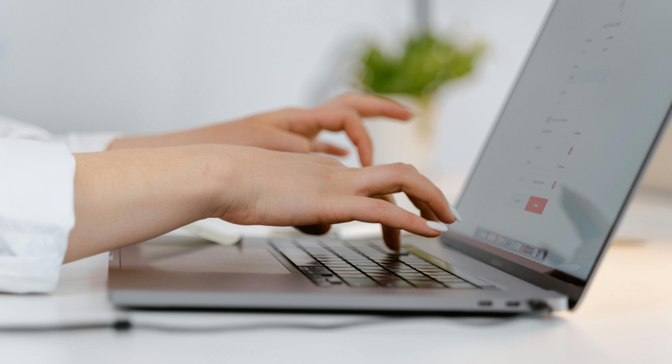 womans hands typing on laptop